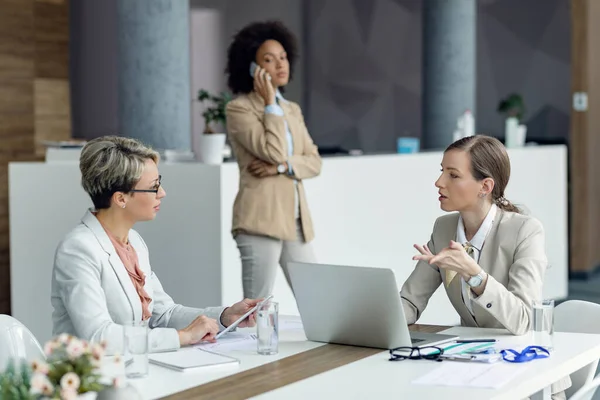 Two Businesswomen Communicating While Working Wireless Technology Office Colleague Talking — Φωτογραφία Αρχείου