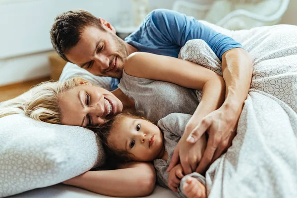 Young Happy Family Embracing While Lying Together Bed — Foto de Stock