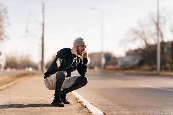 Young Athletic Man Feeling Tired Crouching Jogging Street Copy Space — Stockfoto