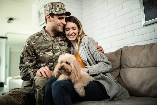 Young happy military couple embracing while reuniting at home.