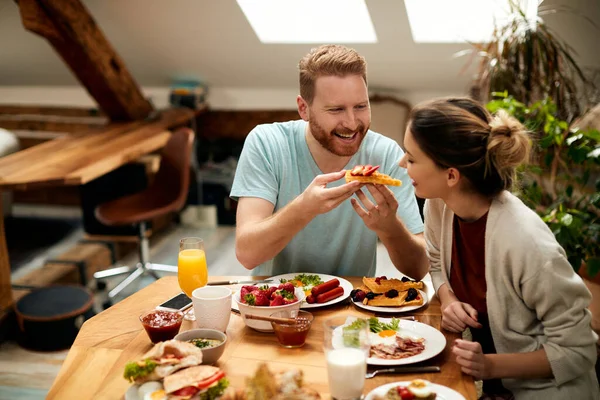 Happy Man Feeding His Girlfriend Waffle Breakfast Home — 스톡 사진