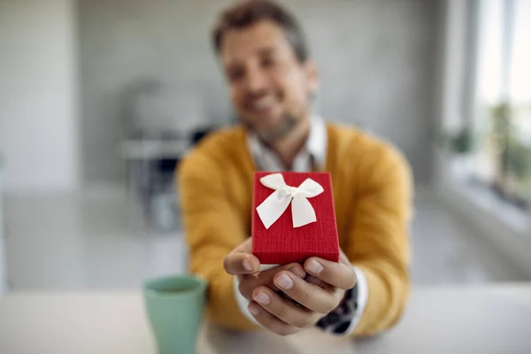 Close-up of man giving a present to someone.