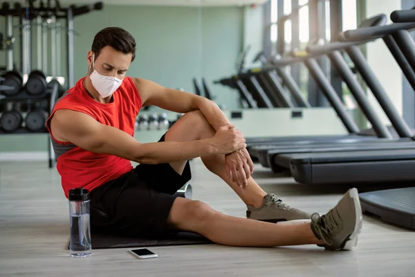 Male Athlete Protective Face Mask Sitting Floor Looking His Phone — Φωτογραφία Αρχείου