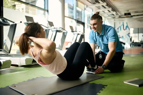 Athletic Woman Exercising Sit Ups Help Personal Trainer Gym Focus — Stockfoto