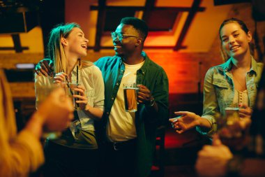 Happy couple dancing and having fun with their friends during their night out in a bar.