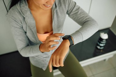 Spor salonundaki spor antrenmanından önce spor takip cihazını ayarlayan kadın.. 