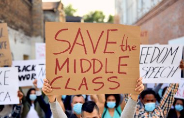 Crowd of unemployed people protesting on the streets after losing their jobs due to coronavirus pandemic. 
