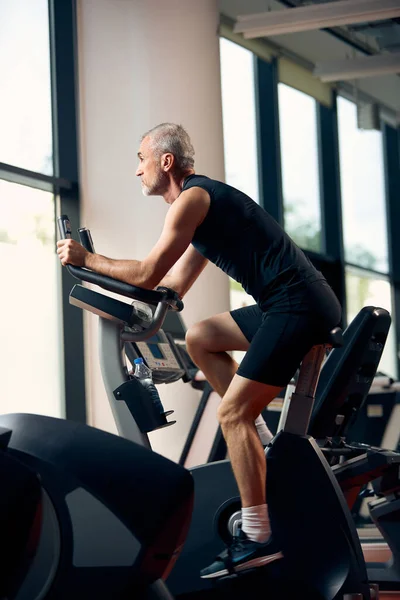 Mature Athletic Man Using Exercise Bike While Working Out Gym — ストック写真