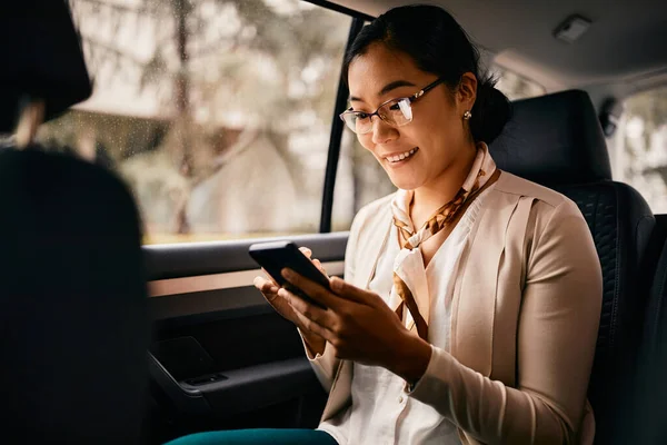 Smiling Asian Female Ceo Sitting Backseat Using Smart Phone While — 图库照片