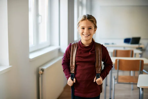 Happy Little Girl Backpack Standing Classroom Elementary School Looking Camera —  Fotos de Stock