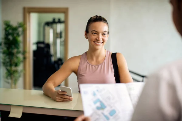 Happy Athletic Woman Communicating Gym Receptionist While Using Mobile Phone —  Fotos de Stock