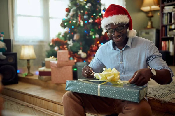 Happy Black Man Enjoying Wrapping Gift Box While Preparing Christmas — ストック写真
