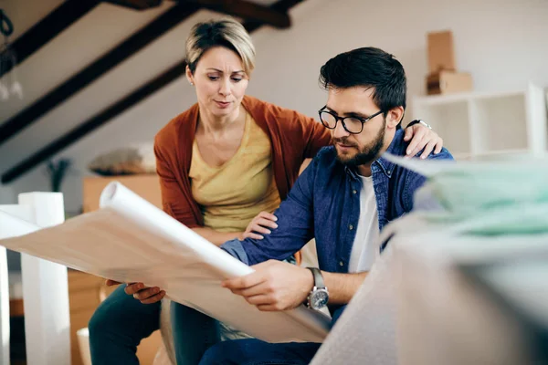 Mid Adult Couple Analyzing Blueprints While Relocating New House — Stockfoto