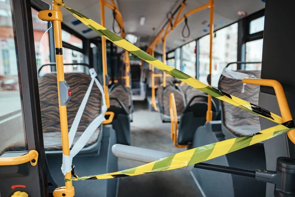 Interior of public bus with warning cordon tape during global COVID-19 epidemic.