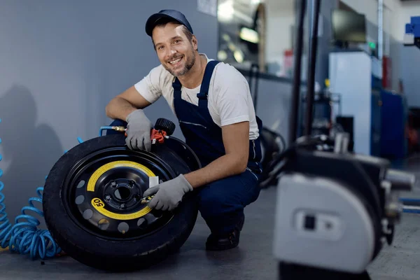 Happy Mechanic Using Pressure Gauge While Repairing Car Tire Workshop — Fotografia de Stock