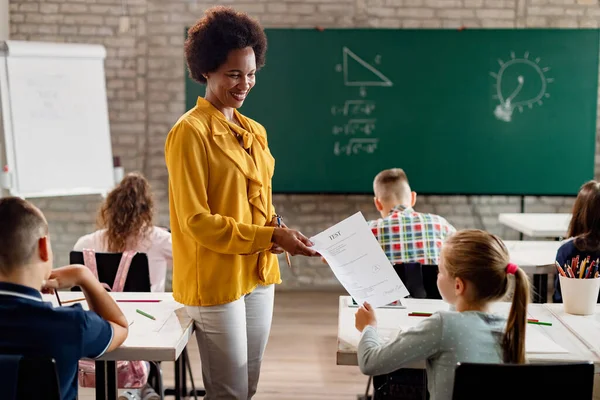 Happy Black Teacher Giving Exam Paper Schoolgirl Class Classroom — Stockfoto