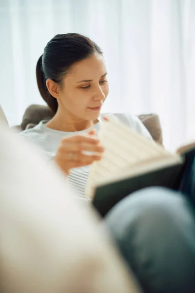 Wanita Muda Menikmati Membaca Buku Sambil Bersantai Rumah — Stok Foto
