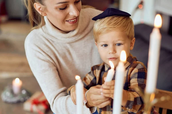 Smiling Mother Teaching Her Small Boy Light Traditional Hanukkah Candles — Stockfoto