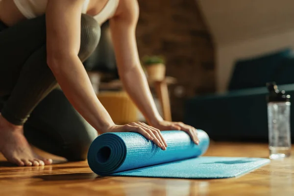 Closeup Of Athletic Woman Rolling Up Her Exercise Mat After