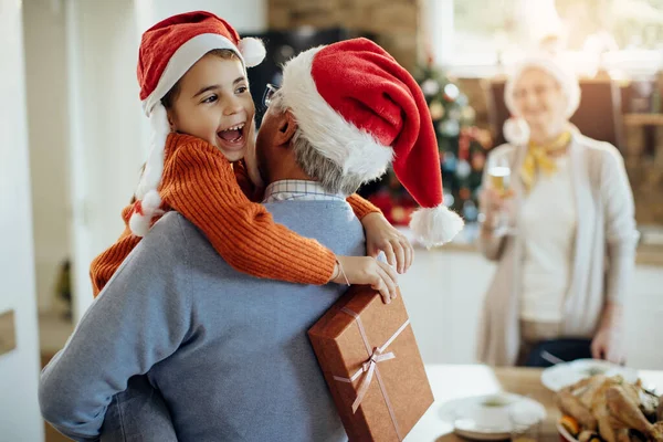 Happy Small Girl Embracing Her Grandfather While Receiving Christmas Present — ストック写真
