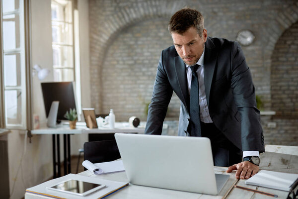 Mid adult entrepreneur using computer while working in the office. 