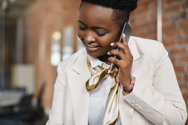 African American businesswoman working at corporate office and making a phone call over mobile phone.