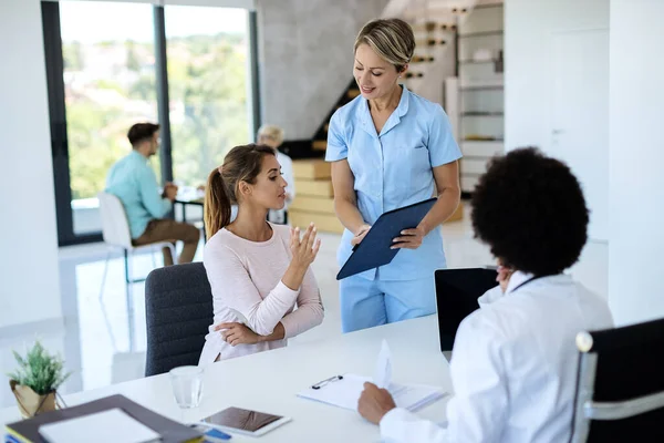 Smiling Nurse Young Woman Filling Paperwork Medical Appointment Doctor Clinic — Fotografia de Stock