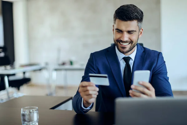 Happy Businessman Using Smart Phone Credit Card Online Shopping While — Zdjęcie stockowe