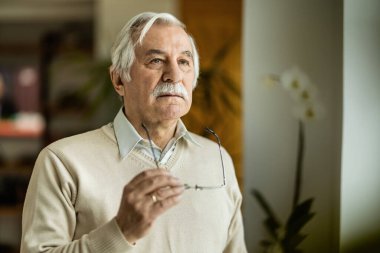 Gözlüklü ve düşünceli yaşlı bir adamın portresi.. 