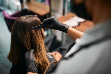 Close-up of woman getting her hair styled at hairdresser's.
