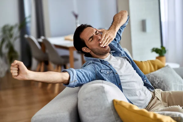 Young Man Feeling Exhausted Yawning While Sitting Living Room — Stockfoto