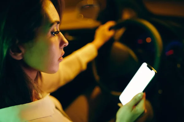 Close Woman Driving Car Night While Using Smart Phone — 图库照片
