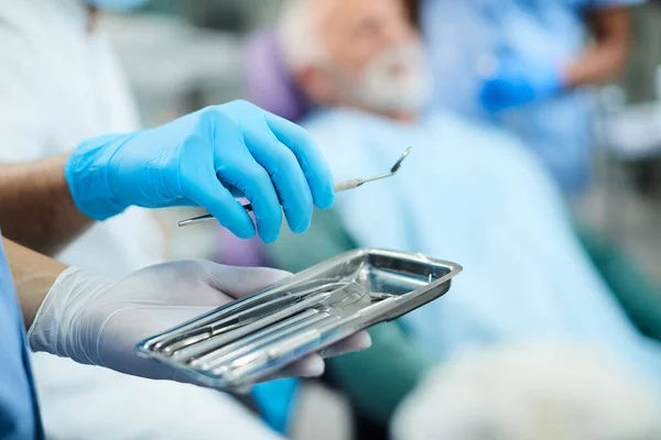 Close-up of dentist performing dental exam with dental tools at dentist\'s office.