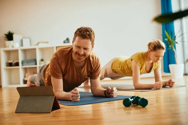 Happy Man His Girlfriend Working Out Home Doing Exercise Plank — Stockfoto