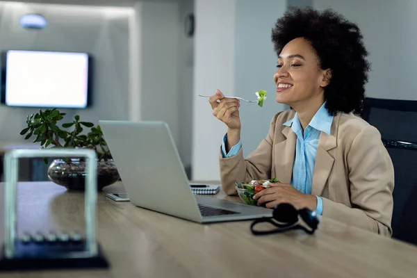 Happy African American Businesswoman Surfing Net Computer While Eating Salad — ストック写真