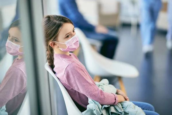 Pensive Small Girl Face Mask Waiting Medical Appointment Hallway Hospital — 스톡 사진