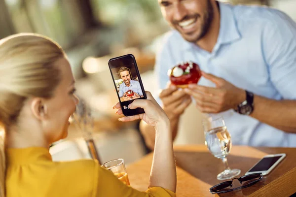 Close Woman Taking Picture Her Boyfriend Who Eating Donut Cafe —  Fotos de Stock