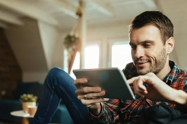 Young Happy Man Reading Something Touchpad While Relaxing Living Room — Φωτογραφία Αρχείου