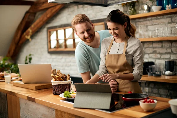 Happy Couple Using Digital Tablet Searching Recipe Online While Preparing — 스톡 사진