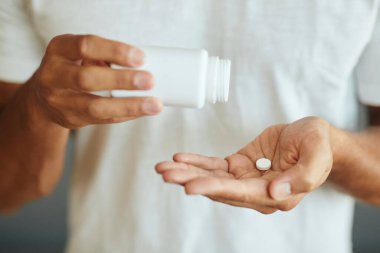 Close-up of unrecognizable man taking medicine.