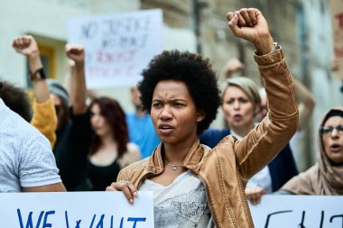 Displeased black woman and crowd of people demonstrating against racism on city streets. 