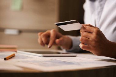 Close-up of businesswoman using credit card and touchpad while buying on the Internet. 