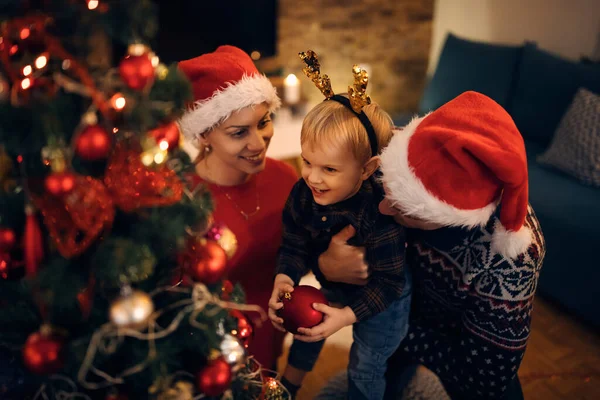Happy Small Boy His Parents Decorating Christmas Tree Evening Home — ストック写真
