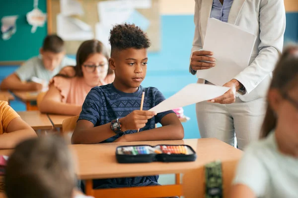 African American Schoolboy Receiving Test Results His Teacher Class Classroom — Stock Fotó