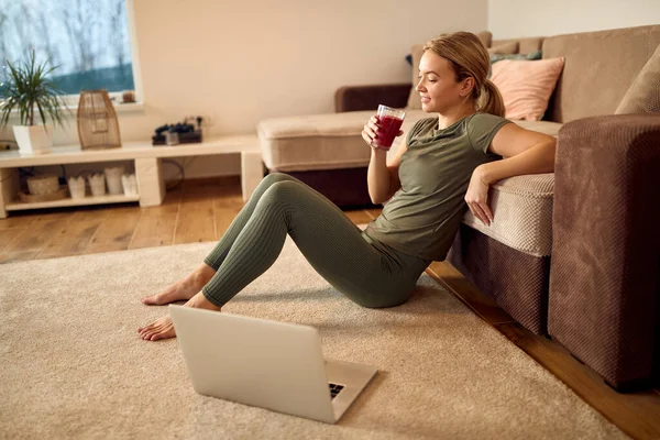 Athletic Woman Relaxing Floor Drinking Smoothie While Using Laptop Living —  Fotos de Stock