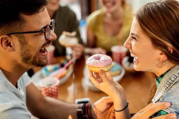 Young Happy Couple Laughing Having Fun While Eating Glazed Donuts — Photo