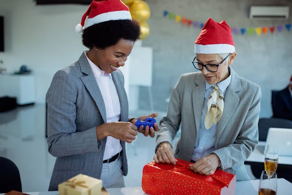 Happy African American Businesswoman Her Mature Colleague Wrapping Christmas Present — ストック写真