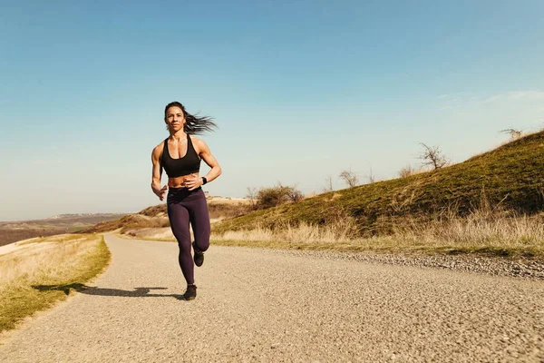 Full Length Female Fitness Instructor Jogging Road While Exercising Outdoors — Fotografia de Stock