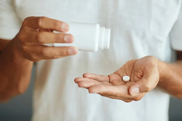 Close-up of unrecognizable man taking medicine.