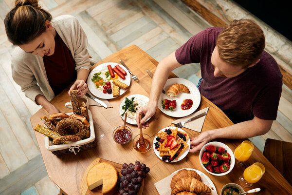 High angle view of couple having breakfast at dining table at home.